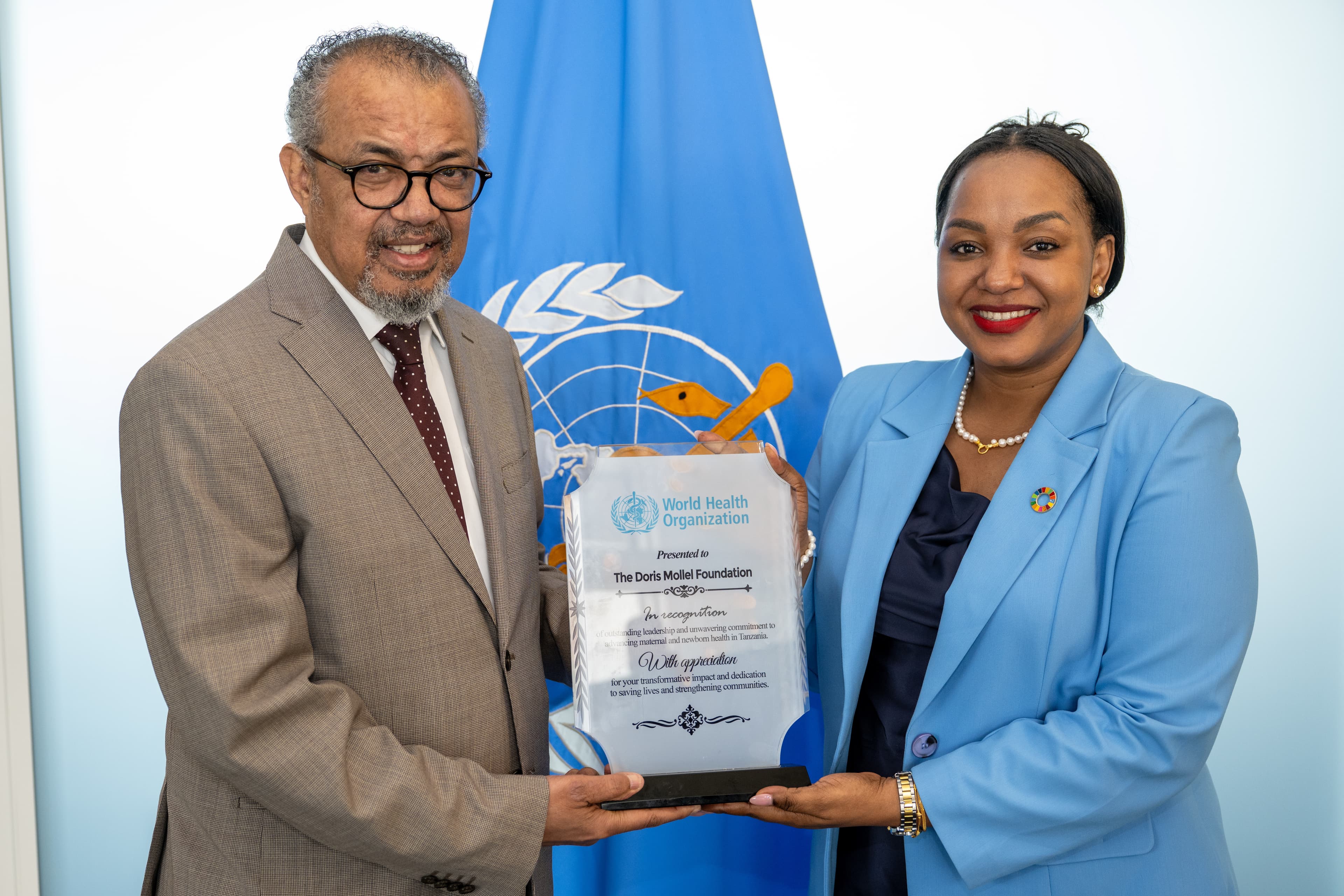 WHO Director-General Tedros Adhanom Ghebreyesus presents an award to Doris Mollel Foundation Executive Director Doris Mollel at WHO headquarters in Geneva